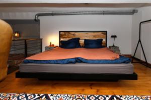 a bedroom with a large bed with blue pillows at Loft Szpularnia in Żyrardów