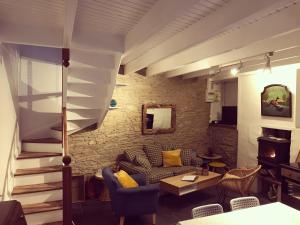 ein Wohnzimmer mit einem Sofa und einer Treppe in der Unterkunft Ker Iliz in Locquirec
