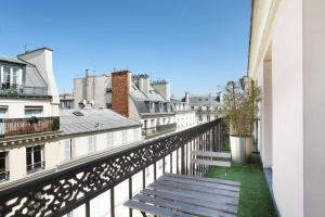een bankje op een balkon met gebouwen bij Maison Nabis by HappyCulture in Parijs