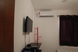 Zimmer mit einem Flachbild-TV an der Wand in der Unterkunft Aldeia St. Sebastien 25 in Arembepe
