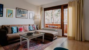 ein Wohnzimmer mit einem Sofa und einem Tisch in der Unterkunft Veli Hills Apartments in Welingrad