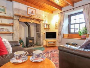 sala de estar con sofá y chimenea en Eldamar Cottage, en Penryn