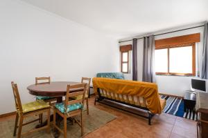 a living room with a table and a table and chairs at Casa Bela in Faro