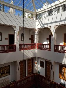 Palais Zahia Hotel & Spa في طنجة: مبنى كبير بشرفات خشبية وسقف زجاجي