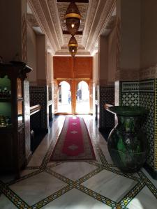 Palais Zahia Hotel & Spa في طنجة: غرفة مع مزهرية كبيرة على أرضية البلاط