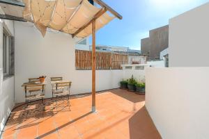 Un patio con una sombrilla y una mesa y sillas. en Casa Gago, en Faro