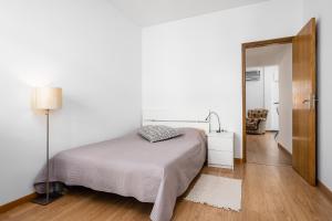 a white bedroom with a bed and a mirror at Casa Gago in Faro