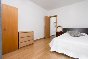Un dormitorio con una cama y una cómoda de madera. en Casa Gago, en Faro