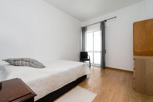 Un dormitorio blanco con una cama y una ventana. en Casa Gago, en Faro 6 fotos más