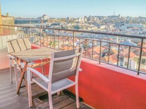 
a wooden chair sitting on top of a balcony overlooking a city at PipaD'oro by YoursPorto in Porto
