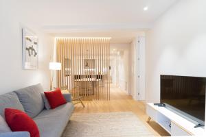 uma sala de estar com um sofá e uma televisão em Fermin Suite - Iberorent Apartments em San Sebastián