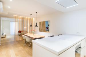 cocina y comedor con mesa y sillas en Fermin Suite - Iberorent Apartments, en San Sebastián