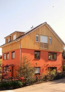 un grand bâtiment orange avec un bois dans l'établissement Haus Meersburg See, à Meersburg