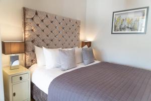 a bedroom with a large bed with a purple bedspread at Citystay - Marino Place in Cambridge