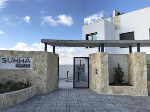 a rendering of a villa with a stone wall at Sukha Nara Apartment 47 in Gran Alacant