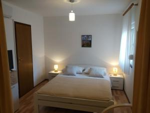 niewielka sypialnia z łóżkiem i 2 lampami w obiekcie Apartment Petra w mieście Brodarica