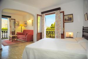 a bedroom with a bed and a living room at Hostal Los Pinos in Cala de Sant Vicenc