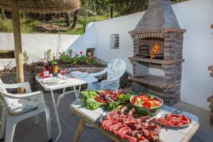 a table with a brick oven with food on it at Hostal Los Pinos in Cala de Sant Vicenc