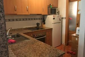 a kitchen with a sink and a white refrigerator at The Beach Apartment - Sea views in Cabo de Palos