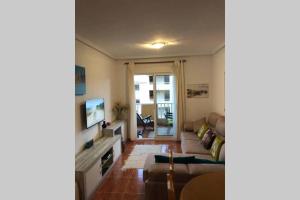 a living room with a couch and a tv at The Beach Apartment - Sea views in Cabo de Palos