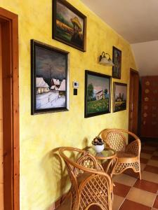 a dining room with a table and chairs and paintings on the wall at Hotel Zéta in Lenti