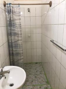 ein Bad mit einem Waschbecken und einer Dusche in der Unterkunft Casa Romano Hostel in San Juan del Sur