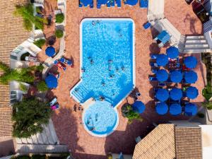 an overhead view of a swimming pool with blue chairs at Villaggio Cala Mancina in San Vito lo Capo