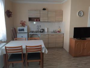 eine Küche mit einem Tisch, Stühlen und einer Mikrowelle in der Unterkunft Ubytovanie v súkromí in Turčianske Teplice