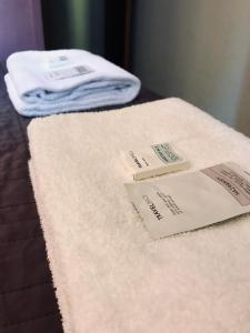 a bed with two hotel towels on top of it at Hôtel des Ambassadeurs in Toulouse