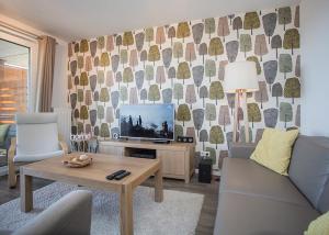 a living room with a couch and a tv at Ferienwohnung Panoramablick Postwiese in Winterberg-Neuastenberg in Winterberg