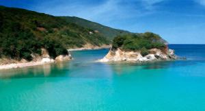 a large body of blue water with a small island at Blue Living-Borgo Antico in Marciana Marina