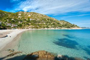 a view of a beach with a hill in the background at Blue Living-Borgo Antico in Marciana Marina
