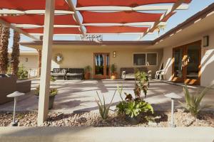 a patio with a red umbrella and some plants at Lido Palms Resort & Spa in Desert Hot Springs