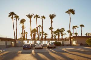 um parque de estacionamento com carros estacionados em frente a palmeiras em Lido Palms Resort & Spa em Desert Hot Springs