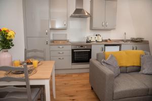a kitchen with a couch and a table in a room at Finest Retreats - Nelly's Nook in Matlock