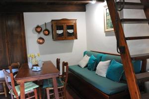 a living room with a green couch and a table at Dépendance Viburni in Alghero