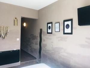 a room with pictures on a wall with a tv at Hotel le Provençal in Narbonne-Plage +27 photos