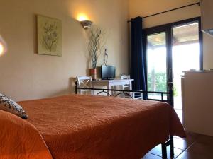 a bedroom with a bed and a sliding glass door at Agriturismo Campesi casale tra le vigne in Aglientu