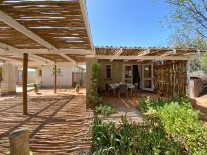 a patio of a house with a wooden pergola at Gasteria Grange in Calitzdorp