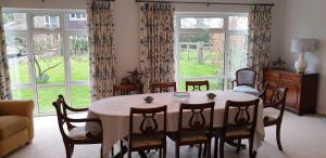 a dining room with a table and chairs and windows at Cobblestones in Benington