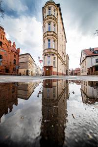 a reflection of a building in a puddle of water at Apartamenty Dominikańskie 2 in Toruń
