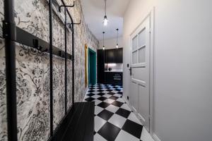 a hallway with a door and a black and white checkered floor at Apartamenty Dominikańskie 2 in Toruń