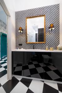a bathroom with a mirror and a checkered floor at Apartamenty Dominikańskie 2 in Toruń