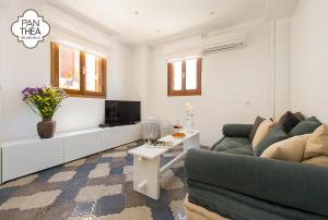 uma sala de estar com um sofá e uma televisão em Villa Panthea em Lindos