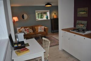 a kitchen and living room with a couch and a table at La Bohème in Tynaarlo
