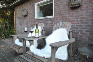 a table with two chairs and a bottle of wine at La Bohème in Tynaarlo +9 photos
