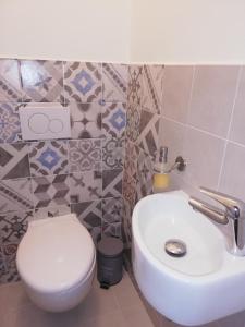 ein Badezimmer mit einem weißen WC und einem Waschbecken in der Unterkunft Apartman Oasis in Žilina