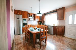 uma cozinha com uma mesa e cadeiras e um frigorífico em Villa Morada Sonneland con piscina privada climatizada em Maspalomas