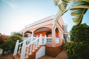 馬斯帕洛馬斯的住宿－Villa Morada Sonneland con piscina privada climatizada，白色栏杆和楼梯的房子