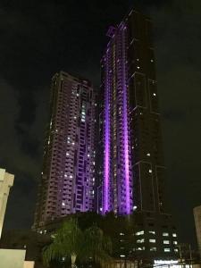 a tall building with purple lights on it at night at HORIZON 101 A4 near robinson mall Free POOL WIFI in Cebu City